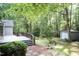 Backyard view featuring a wooden deck, manicured landscaping, and a storage shed at 140 Baron Cir, Youngsville, NC 27596