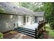 Backyard with a wooden deck, lawn, mulch beds and mature trees at 140 Baron Cir, Youngsville, NC 27596