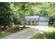 Inviting home with a long driveway, well-maintained landscaping, and mature trees providing shade at 140 Baron Cir, Youngsville, NC 27596