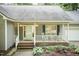 Close-up of a charming front porch with rocking chairs, lovely landscaping, and a welcoming entrance at 140 Baron Cir, Youngsville, NC 27596
