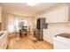Bright kitchen featuring stainless steel fridge and adjacent breakfast nook with ample natural light from the sheer curtains at 140 Baron Cir, Youngsville, NC 27596