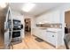 Well-lit kitchen with white cabinets, modern stainless steel appliances, and sleek countertops, creating an efficient cooking space at 140 Baron Cir, Youngsville, NC 27596