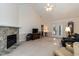 Bright living room with a stone fireplace, carpet floors, and access to the backyard through french doors at 140 Baron Cir, Youngsville, NC 27596