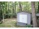 A storage shed sits in the backyard surrounded by trees at 140 Baron Cir, Youngsville, NC 27596