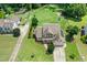 Aerial view of a home with a well-manicured lawn, long driveway, and solar panels on the roof at 142 Scarlet Oak Run, Clayton, NC 27520