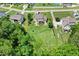 Aerial view of a home with large backyard, screened porch, patio area, and lush surrounding greenery at 142 Scarlet Oak Run, Clayton, NC 27520