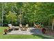Cozy backyard patio with a fire pit, comfortable seating, and a relaxing hammock surrounded by lush greenery at 142 Scarlet Oak Run, Clayton, NC 27520