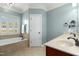 A luxurious tub sits near a double sink vanity in this relaxing bathroom with natural light and neutral colors at 142 Scarlet Oak Run, Clayton, NC 27520