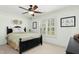 A neutral toned bedroom with white walls and light carpet, featuring dark wood furniture and a window with plantation shutters at 142 Scarlet Oak Run, Clayton, NC 27520