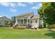 Beautiful home exterior with a screened-in porch, large patio, green lawn, and meticulously maintained landscaping at 142 Scarlet Oak Run, Clayton, NC 27520