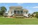 Spacious home exterior with a screened porch, large patio, manicured lawn, and beautiful landscaping at 142 Scarlet Oak Run, Clayton, NC 27520