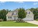 Charming two-story home featuring a well-manicured lawn and attached two-car garage at 142 Scarlet Oak Run, Clayton, NC 27520