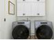 Practical laundry room with washer, dryer, and storage cabinets at 142 Scarlet Oak Run, Clayton, NC 27520