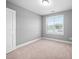 A light-filled bedroom showcases neutral walls, plush carpet, and a window offering outdoor views at 147 Sunfish St, Smithfield, NC 27577