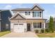 Charming two-story home with a white garage door, stone accents, and a manicured lawn on a sunny day at 147 Sunfish St, Smithfield, NC 27577