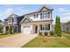 Charming two-story home with a white garage door, stone accents, and a manicured lawn on a sunny day at 147 Sunfish St, Smithfield, NC 27577