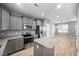 Modern kitchen with gray cabinets, stainless steel appliances, granite countertops and an island at 147 Sunfish St, Smithfield, NC 27577