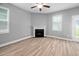 Living room featuring a fireplace, ceiling fan, wood-look flooring and neutral paint at 147 Sunfish St, Smithfield, NC 27577