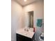 Bright bathroom featuring modern vanity, a sleek mirror, and a towel rack with a teal towel at 1476 Burgundy Bluff Ln, Zebulon, NC 27597