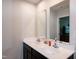 Bathroom featuring modern dual sinks, white countertops and dark wood cabinetry, with mirrors at 1476 Burgundy Bluff Ln, Zebulon, NC 27597