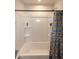 Clean bathroom featuring a bathtub and shower with a fun banana-themed curtain and built-in shelving at 1476 Burgundy Bluff Ln, Zebulon, NC 27597