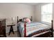 Cozy bedroom features a charming wooden bed frame, side table, and natural light from the window at 1476 Burgundy Bluff Ln, Zebulon, NC 27597