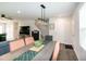 Open-concept dining area with stylish light fixture and view of staircase, seamlessly integrates into the living space at 1476 Burgundy Bluff Ln, Zebulon, NC 27597