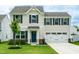 Inviting two-story home with a two-car garage, complemented by fresh landscaping and a well-manicured lawn at 1476 Burgundy Bluff Ln, Zebulon, NC 27597