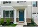 Close-up of the blue front door framed by white pillars and manicured landscaping at 1476 Burgundy Bluff Ln, Zebulon, NC 27597