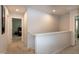 Upstairs hallway with neutral carpet leading to multiple bedrooms and containing white banister at 1476 Burgundy Bluff Ln, Zebulon, NC 27597