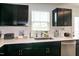Bright kitchen features stainless steel appliances, quartz countertops, ample counter space, and sleek, black cabinets at 1476 Burgundy Bluff Ln, Zebulon, NC 27597