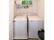 Bright laundry area featuring a modern washer and dryer set with overhead shelving for storage solutions at 1476 Burgundy Bluff Ln, Zebulon, NC 27597