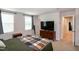 Large bedroom featuring a king size bed, dresser with television, and natural light from windows at 1476 Burgundy Bluff Ln, Zebulon, NC 27597