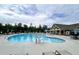 A stunning community swimming pool is surrounded by lounge chairs and umbrellas for relaxing by the water at 1476 Burgundy Bluff Ln, Zebulon, NC 27597