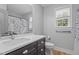 Bathroom with a blue decorative shower curtain, and a single sink vanity with grey cabinets at 149 Great Oak Dr, Garner, NC 27529