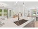 Open-concept kitchen featuring a quartz countertop island and stainless steel sink at 160 Serene Xing, Fuquay Varina, NC 27526