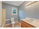 Bathroom featuring toilet, vanity with countertop, window and shower/tub combo at 163 W Lillington St, Angier, NC 27501