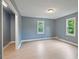 Bedroom features light vinyl flooring, two windows, and grey painted walls at 163 W Lillington St, Angier, NC 27501