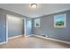 Bedroom featuring light vinyl flooring, two windows, and grey painted walls at 163 W Lillington St, Angier, NC 27501