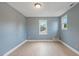 Neutral bedroom features two windows and hardwood floors at 163 W Lillington St, Angier, NC 27501