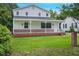 Charming home with a covered porch, white siding, brick accents, and a green lawn at 163 W Lillington St, Angier, NC 27501