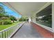 Spacious covered front porch with white railings, brick base, and a concrete floor at 163 W Lillington St, Angier, NC 27501