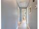 Hallway with light vinyl flooring and gray walls leading to a bathroom at 163 W Lillington St, Angier, NC 27501
