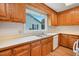 Kitchen featuring ample wood cabinetry and a stainless steel sink with natural light from the window at 163 W Lillington St, Angier, NC 27501