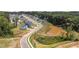 Aerial view of a new residential neighborhood with tree-lined streets and a retention pond at 165 Hickory Grv Dr, Sanford, NC 27330