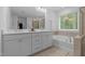 Bathroom featuring a double sink vanity, soaking tub, and a glass shower at 165 Hickory Grv Dr, Sanford, NC 27330