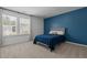 Bedroom features bright window, neutral carpet, and a striking blue accent wall at 165 Hickory Grv Dr, Sanford, NC 27330