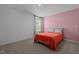 Bedroom with a pink accent wall, neutral carpet, and window providing natural light at 165 Hickory Grv Dr, Sanford, NC 27330