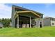 Back exterior showcasing the covered patio with outdoor furniture and a green backyard at 165 Hickory Grv Dr, Sanford, NC 27330