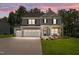 Charming two-story home boasts a three-car garage, welcoming porch, and meticulously landscaped front yard at 165 Hickory Grv Dr, Sanford, NC 27330